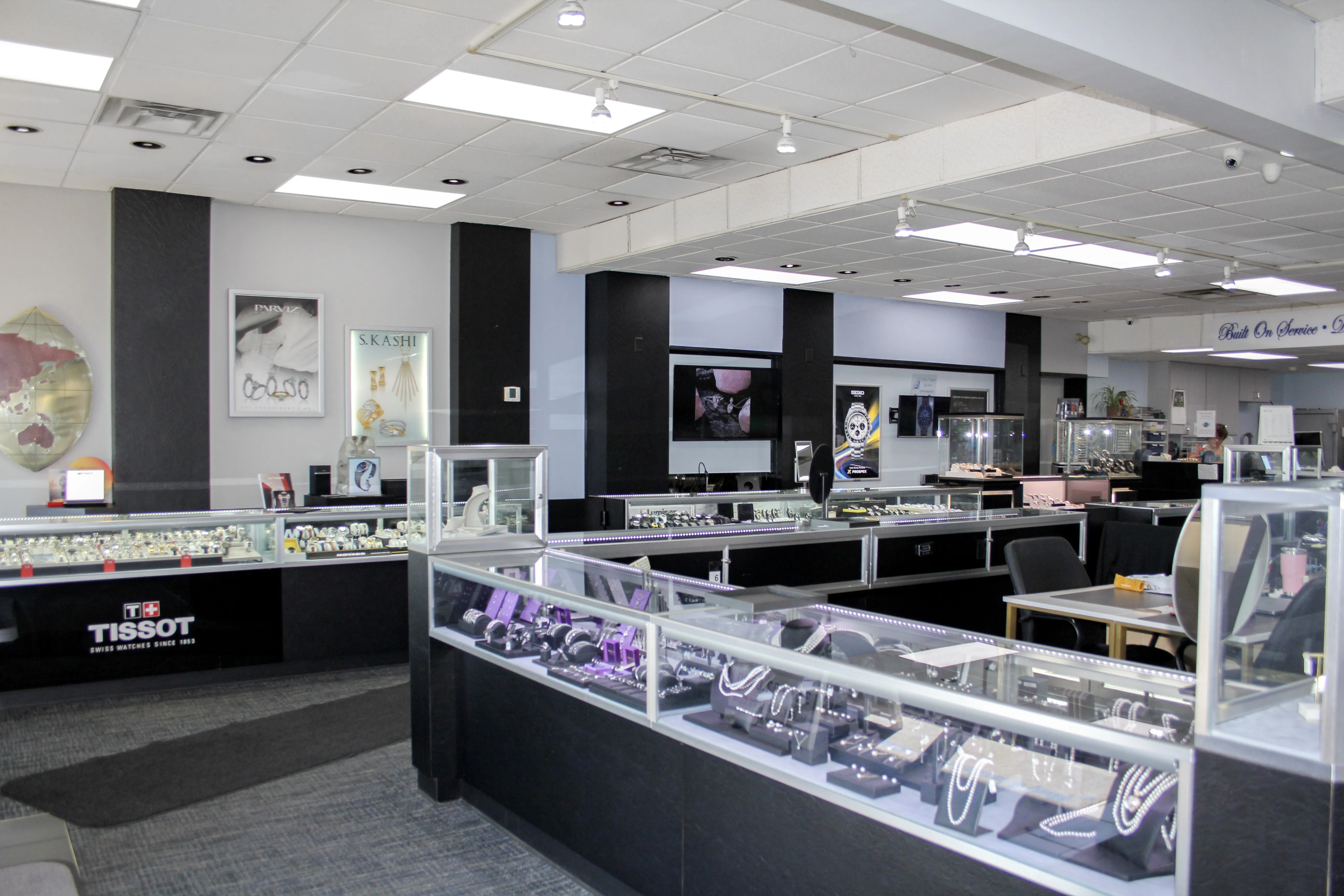 A jewelry store interior with display cases showcasing various jewelry pieces and watches.