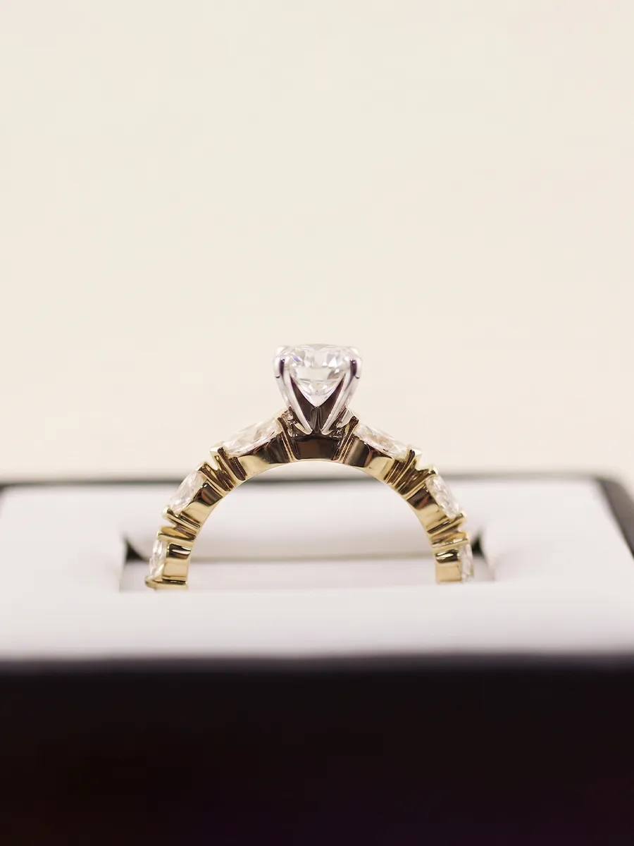 A gold engagement ring with a diamond in a jewelry box.