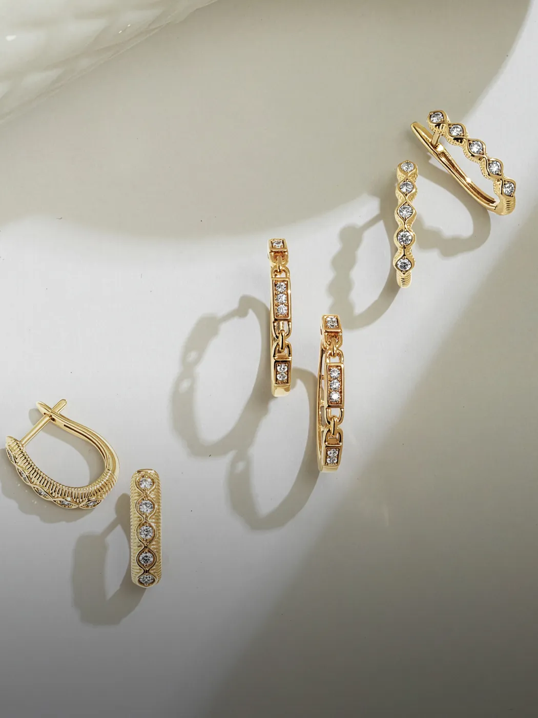 Lab-grown diamond earrings in gold settings on a light background. Explore more at McGee & Company.
