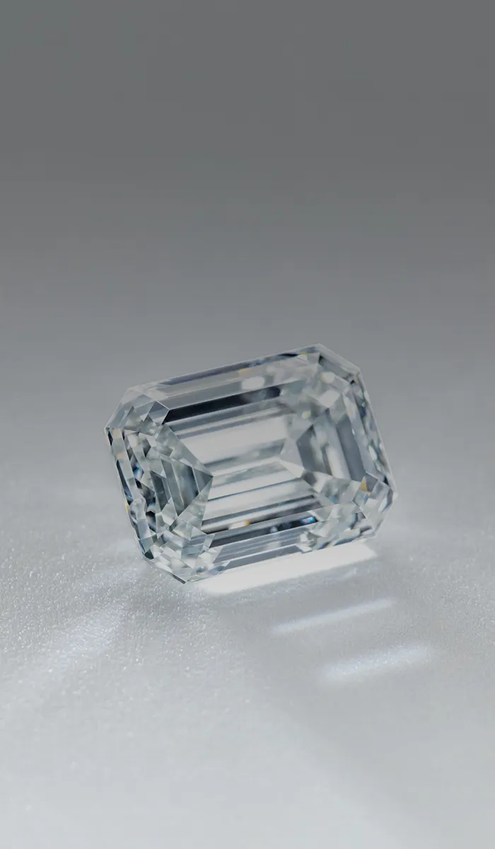 Emerald-cut diamond on a reflective surface.