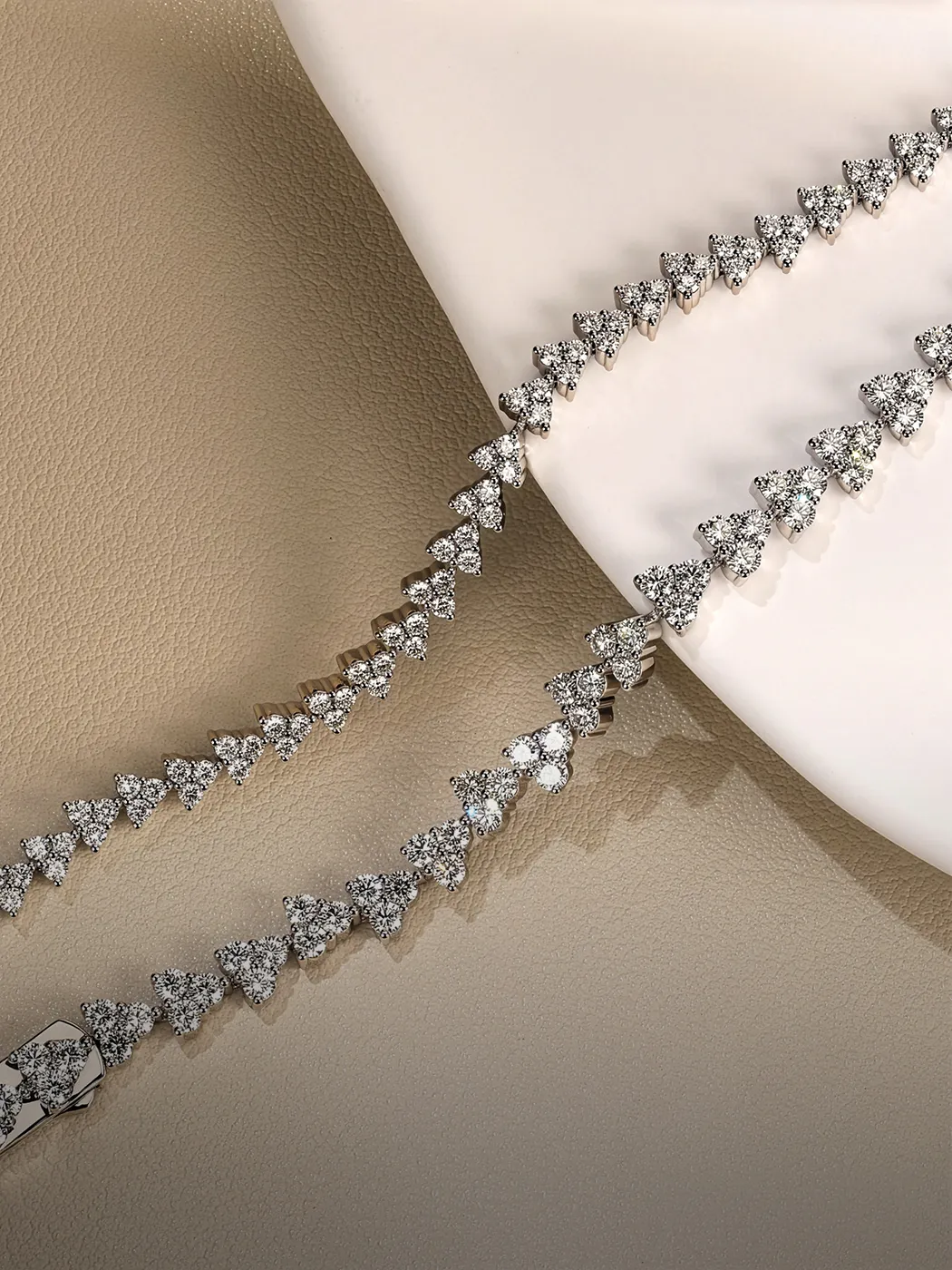 Diamond bracelet with triangle-shaped stones on a textured surface. Explore more at McGee & Company Fine Jewelers.