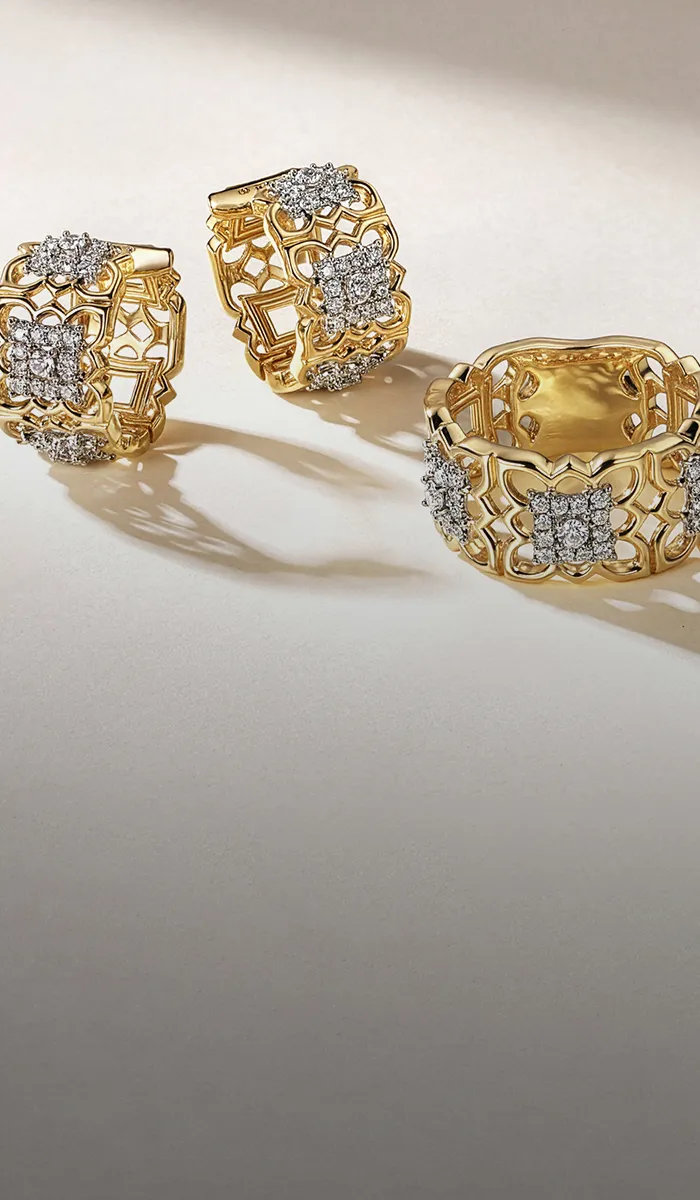 Elegant gold rings with intricate designs and diamond accents on a soft background. Book an Appointment at McGee & Company Fine 