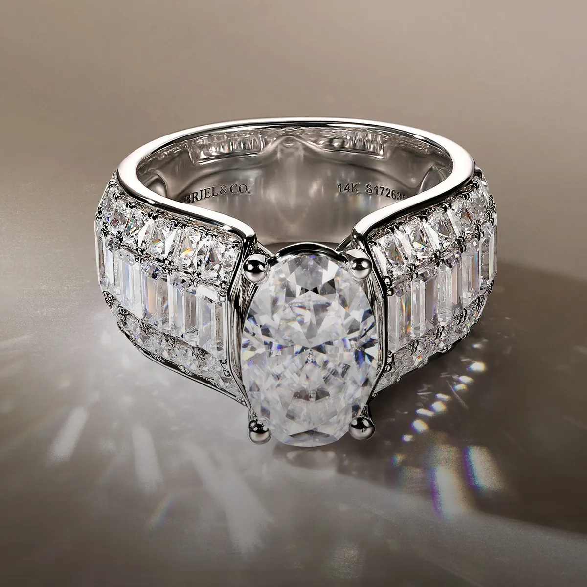 Elegant diamond engagement ring with oval center stone and baguette accents. Explore Gabriel & Co rings at McGee & Company.