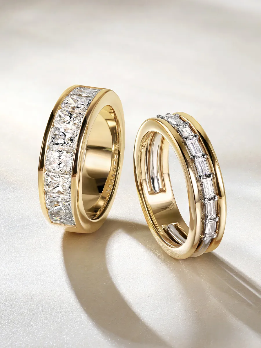 Two gold rings with embedded diamonds on a light background.