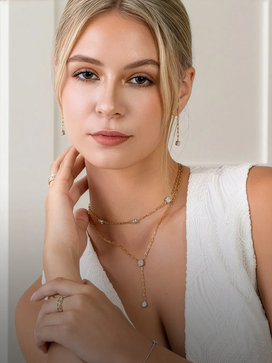 Woman wearing gold jewelry, including necklace and earrings.