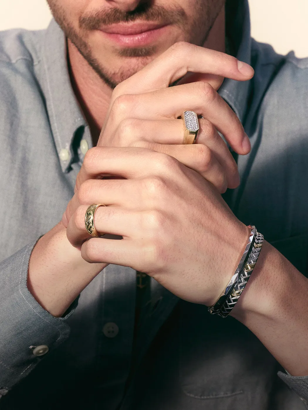 Man wearing rings and bracelets, showcasing men's jewelry.