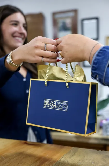 Elegant silver engagement ring with intricate detailing, displayed on colorful geometric backgrounds.