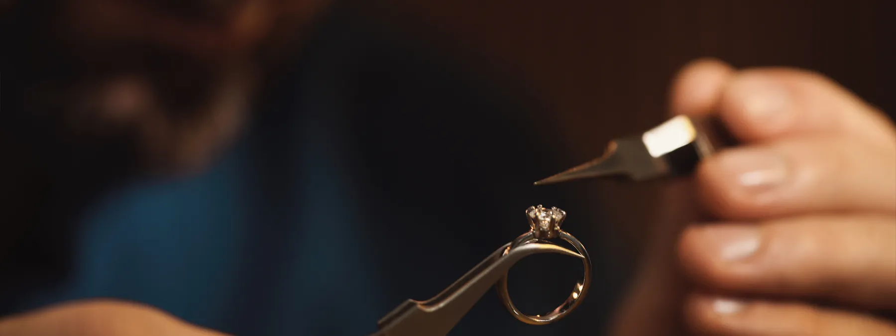 Jeweler inspecting a diamond engagement ring with precision tools