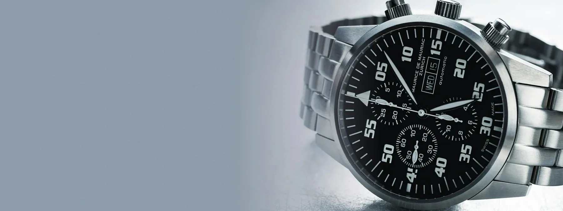 Close-up of a stylish black chronograph watch with a stainless steel band, showcasing vintage and modern design elements.