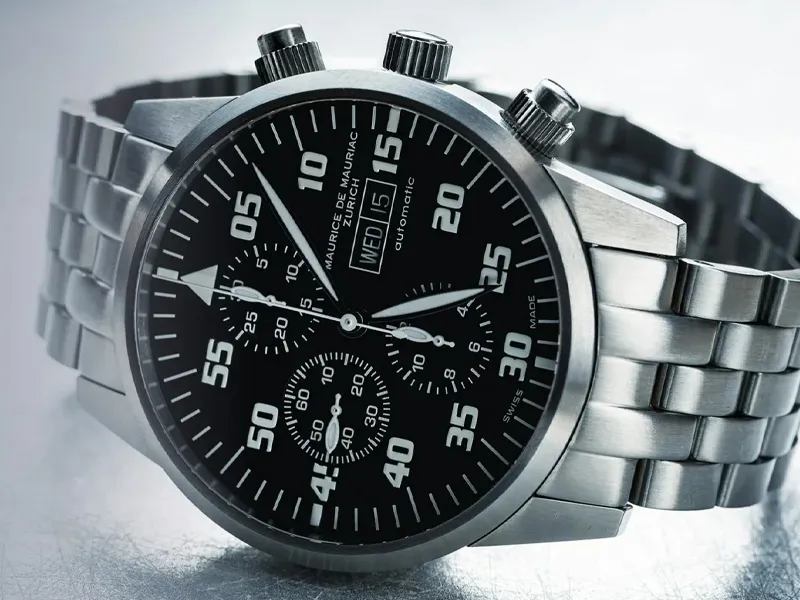 Close-up of a stylish black chronograph watch with a stainless steel band, showcasing vintage and modern design elements.
