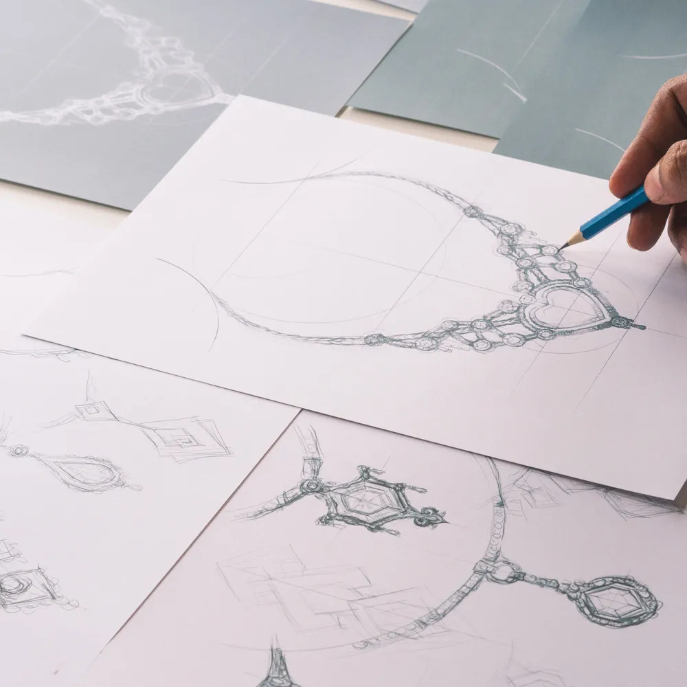 Hand sketching of intricate jewelry designs on paper, showcasing creativity and craftsmanship at Michael & Son's Jewelers.