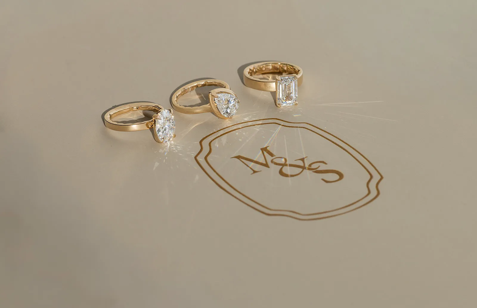 A hand sketching a detailed ring design with a pencil on paper.