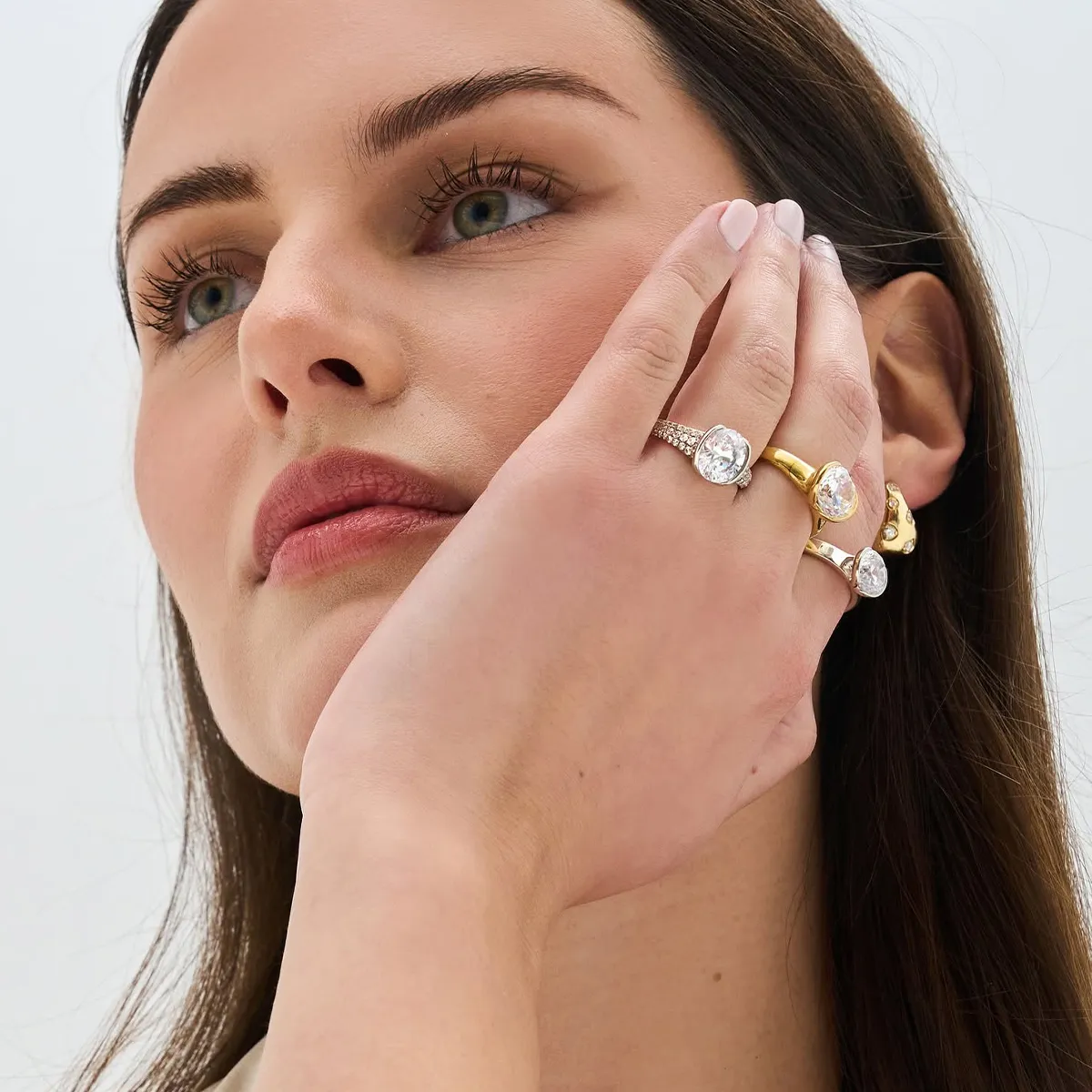 Woman showcasing multiple diamond rings on her fingers.