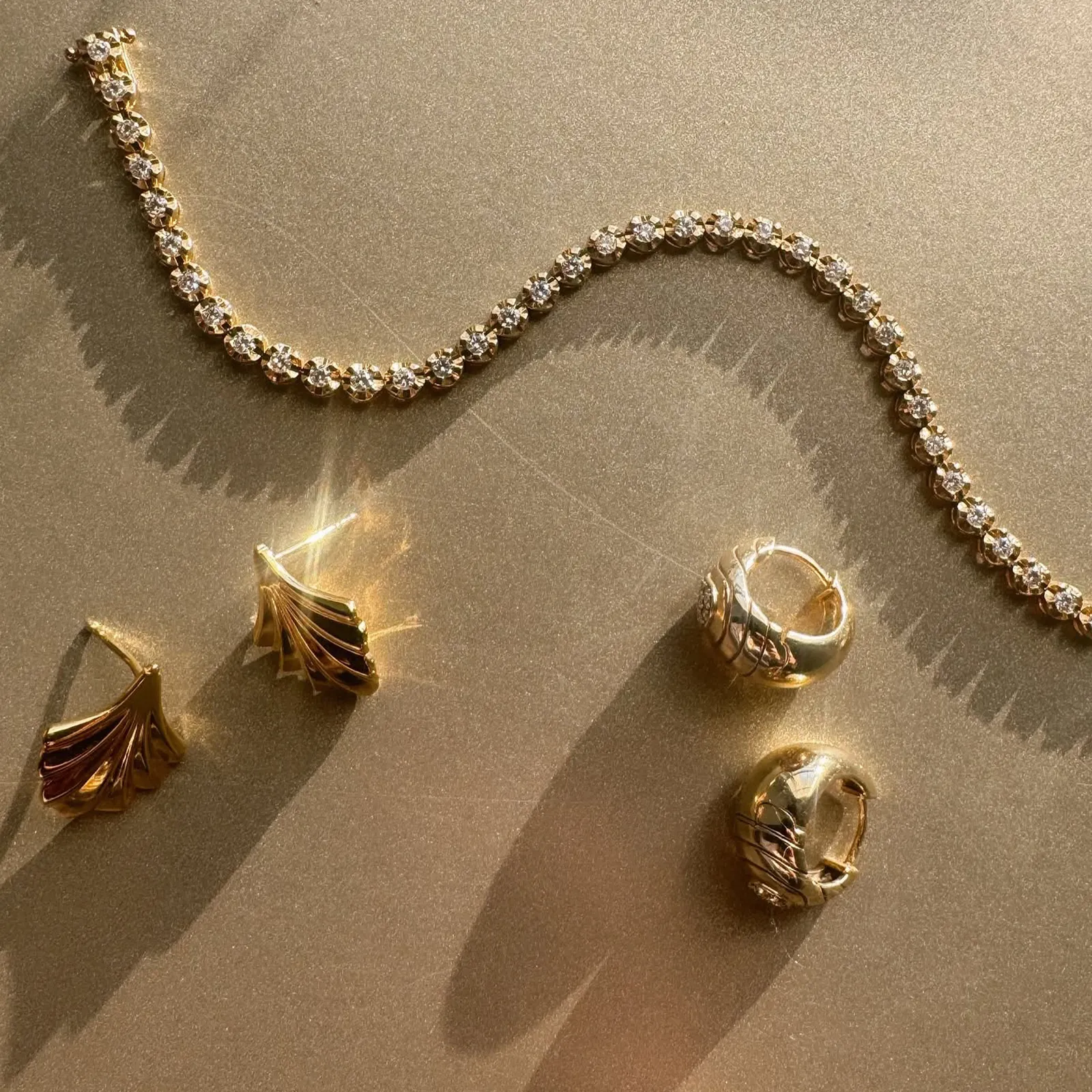 Elegant gold and diamond jewelry set on a reflective surface. Browse Gifts.