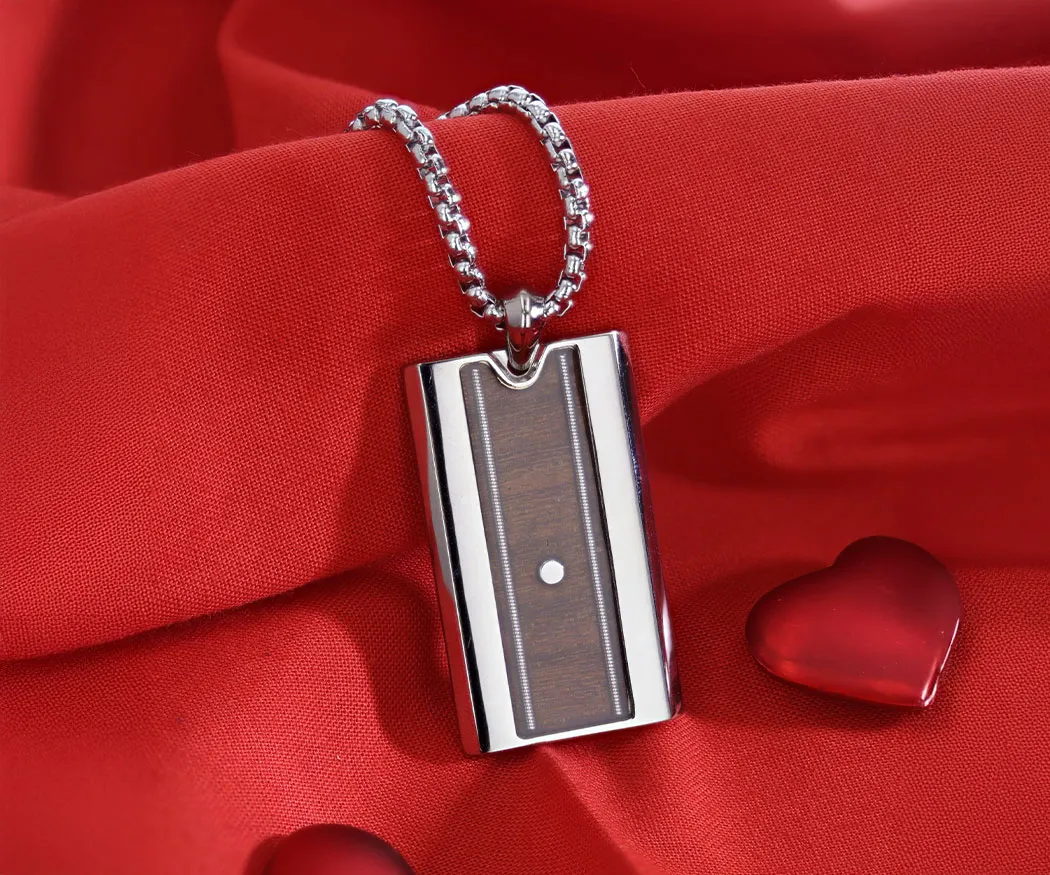 Silver pendant with wooden inlay on a chain, resting on red fabric with heart accents. Shop now at Miner's Den Jewelers.