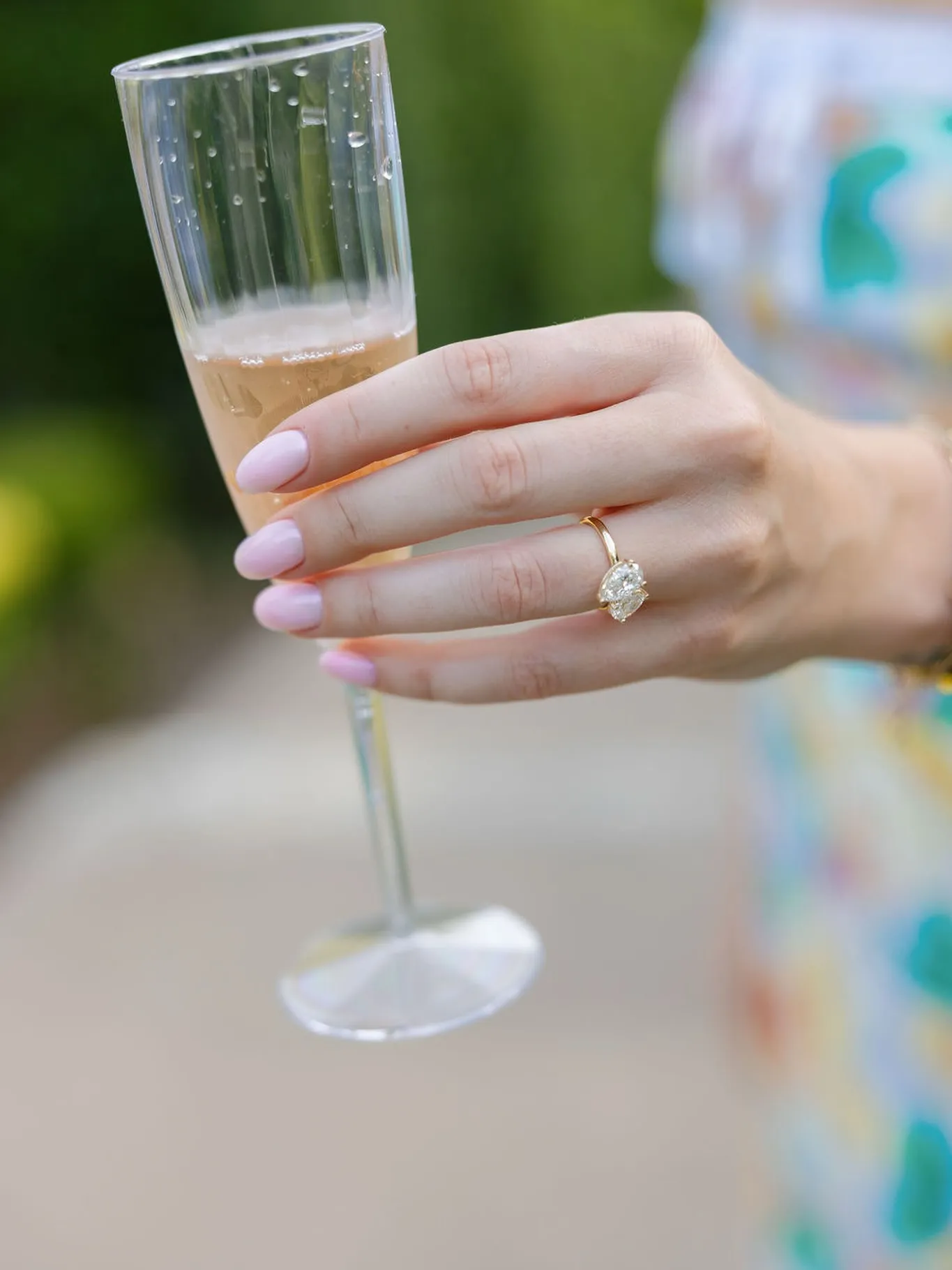 Hand wearing a gold engagement ring with a large diamond.
