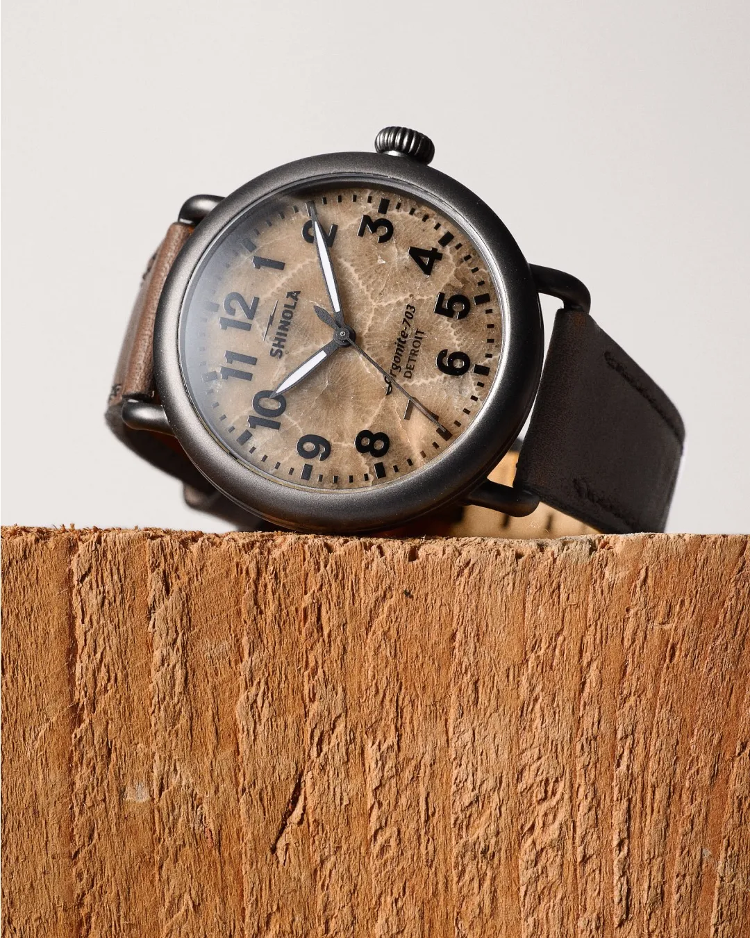Close-up of a wristwatch with a brown leather strap on a person's wrist.