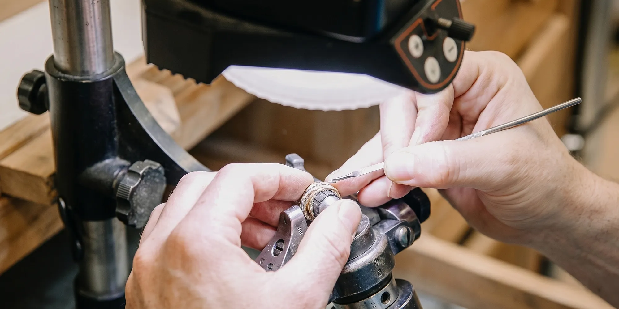 Jeweler working on a ring under a magnifying lamp at Mitchell's Jewelry in Norman.