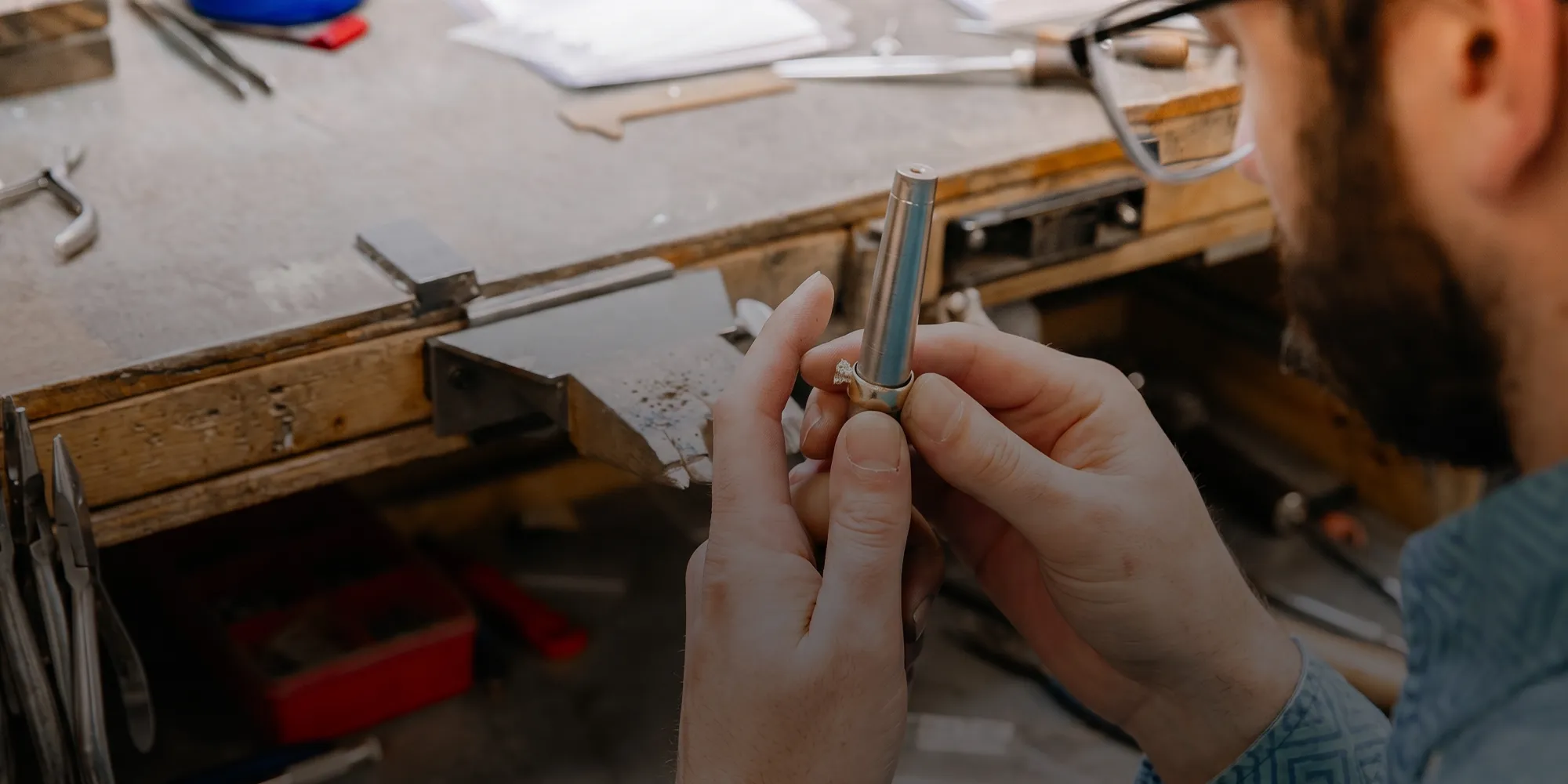 Jeweler working on a ring at a workbench. Book an Appointment.