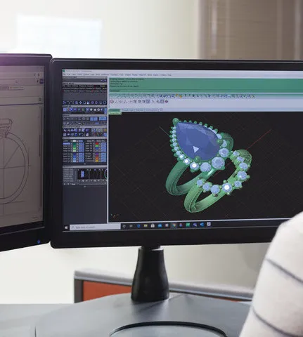 3D design of a gemstone ring displayed on dual monitors at Monarch Jewelry in Winter Park. Click to explore more.