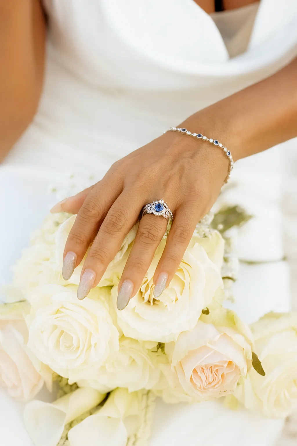 Elegant gold engagement ring with a pear-shaped diamond centerpiece, worn on a woman's hand. Visit Monarch Jewelry for details.
