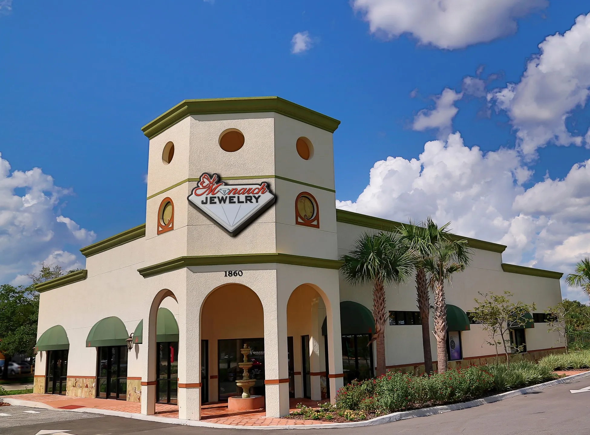 Monarch Jewelry store in Winter Park, showcasing fine jewelry under a blue sky with clouds. Click to learn more.