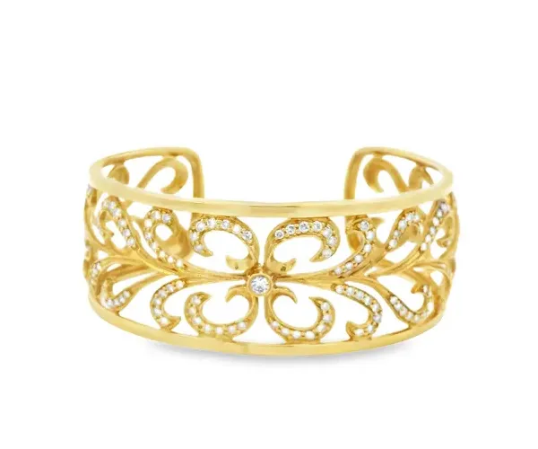 Gold cuff bracelet with intricate floral design and sparkling accents.