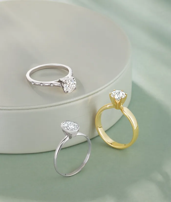 Three elegant diamond rings displayed on a soft surface, inviting you to shop bridal sets at Monarch Jewelry.