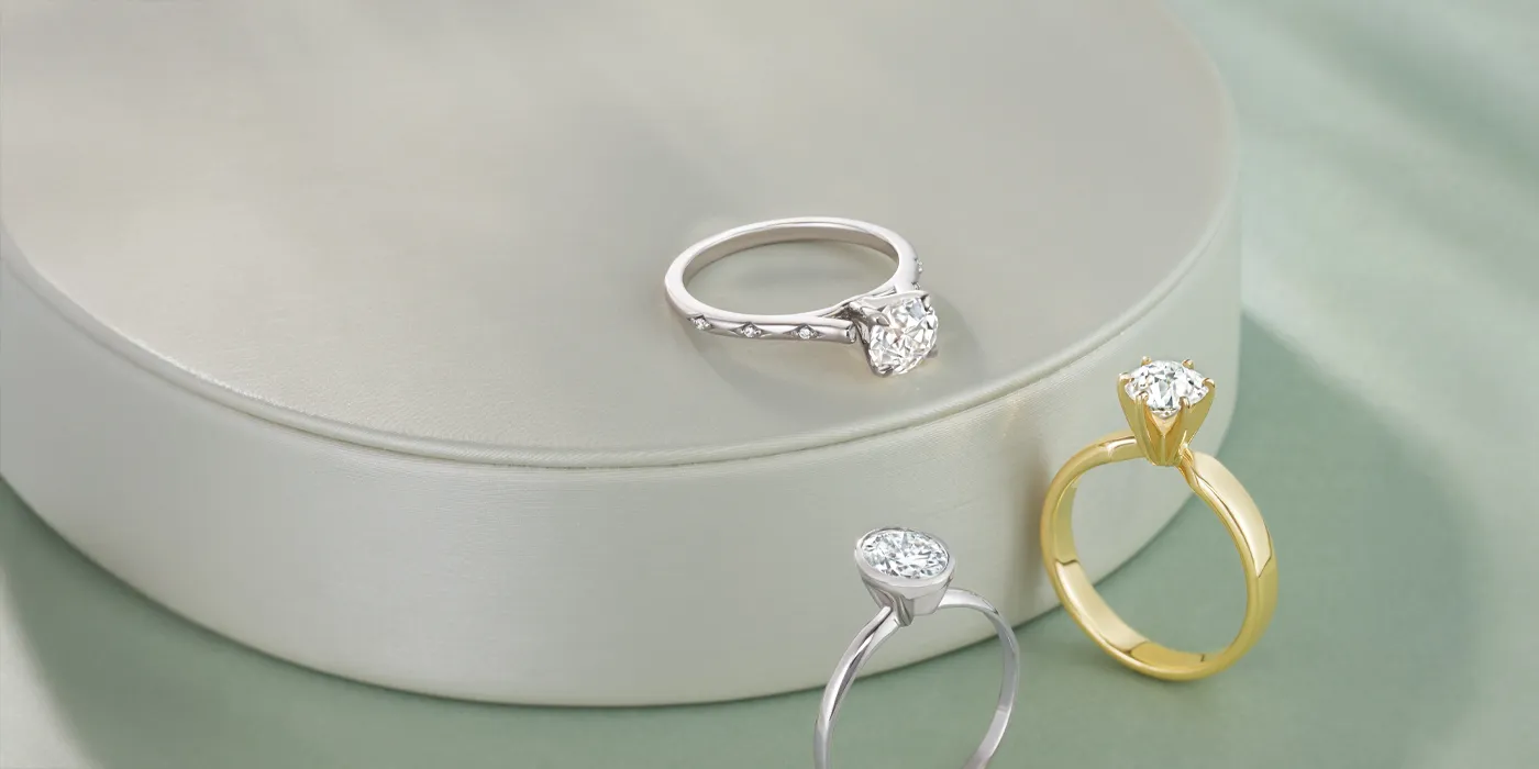 Three elegant diamond rings displayed on a soft surface, inviting you to shop bridal sets at Monarch Jewelry.