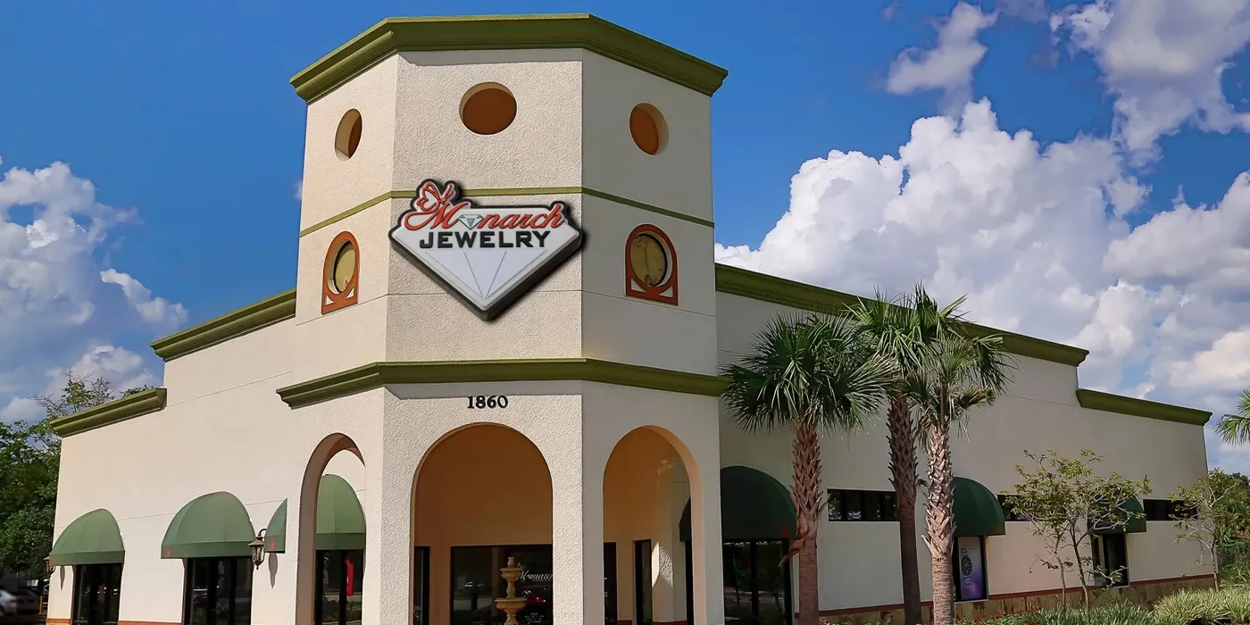 Monarch Jewelry store exterior in Winter Park, featuring a diamond logo and palm trees under a blue sky.