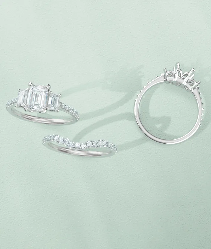 Three elegant silver rings with diamonds on a soft green background. Click to shop designer jewelry at Monarch Jewelry.
