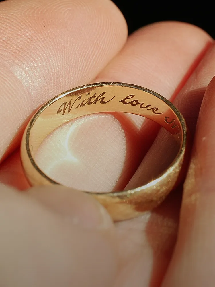 A close-up of a gold ring engraved with 