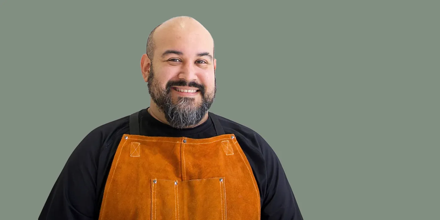 Headshot of Miguel Suncin on a green background
