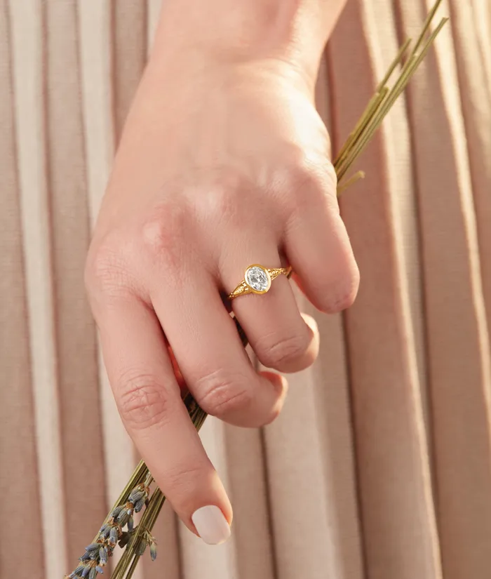 A bride shows off her engagement ring while embracing her groom, highlighting love and joy. Visit Monarch Jewelry for rings.