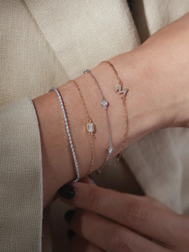 Elegant bracelets stacked on a wrist, showcasing various designs and materials. Shop Bracelets at Monarch Jewelry.