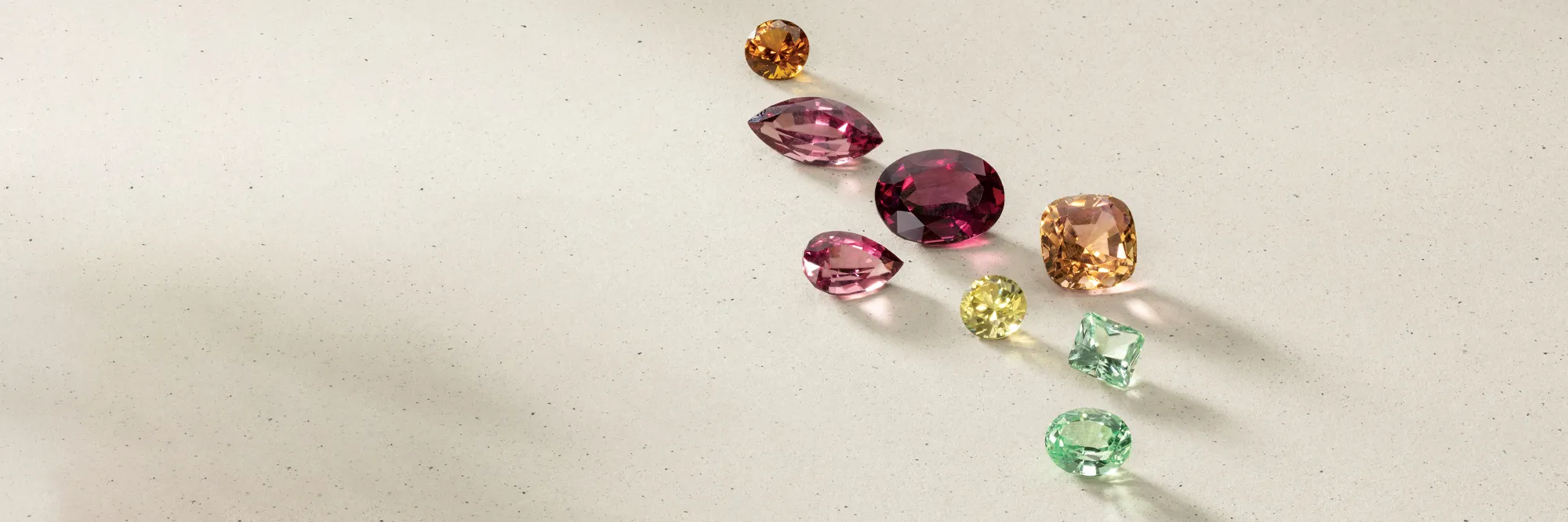 A collection of colorful gemstones spread out on a light surface.