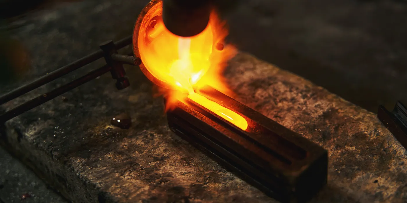 Molten metal being poured into a mold, showcasing the craftsmanship of goldsmiths at Monarch Jewelry. 