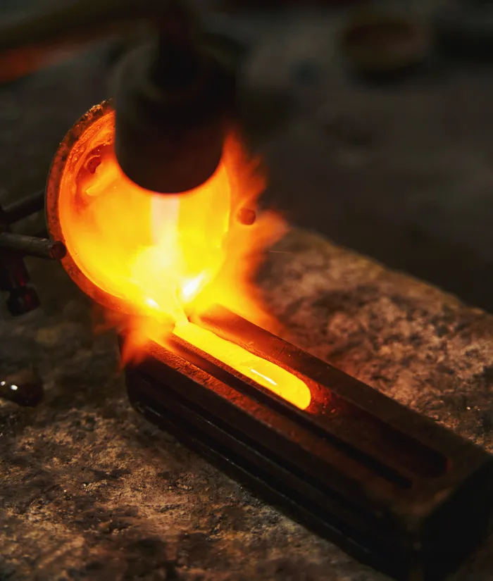 Molten metal being poured into a mold, showcasing the craftsmanship of goldsmiths at Monarch Jewelry. 