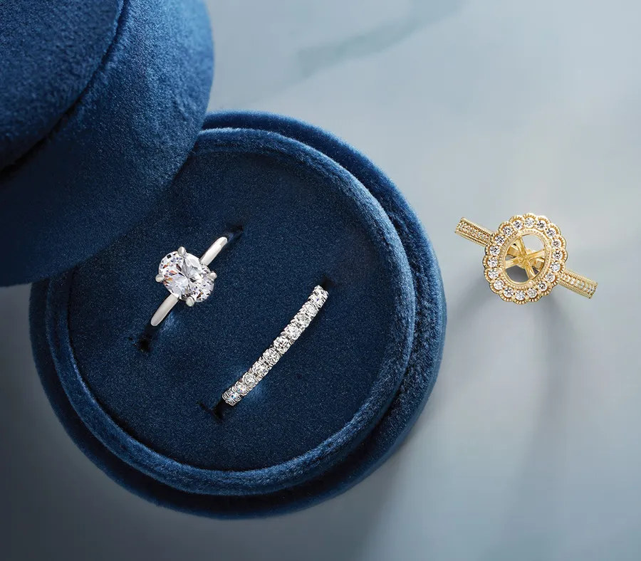 A diamond engagement ring and wedding band in a navy velvet ring box at Morin Jewelers
