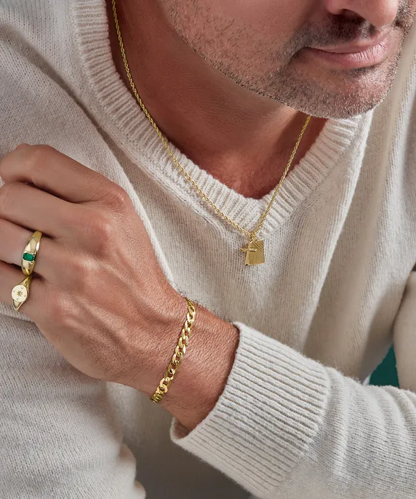 A man wearing a gold chain, bracelet and ring