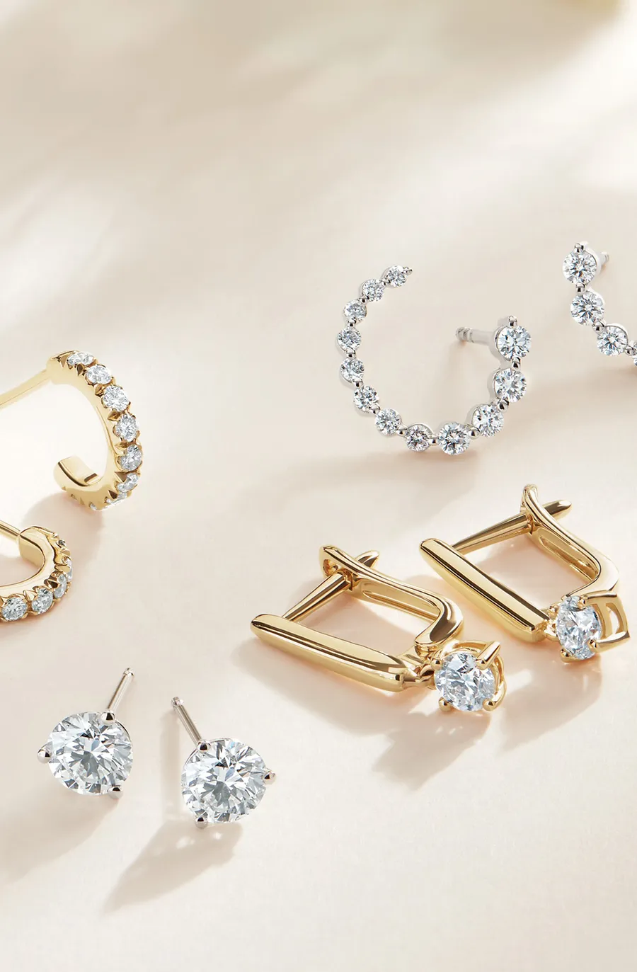 Loose diamonds and diamond earrings laid out side by side for comparison