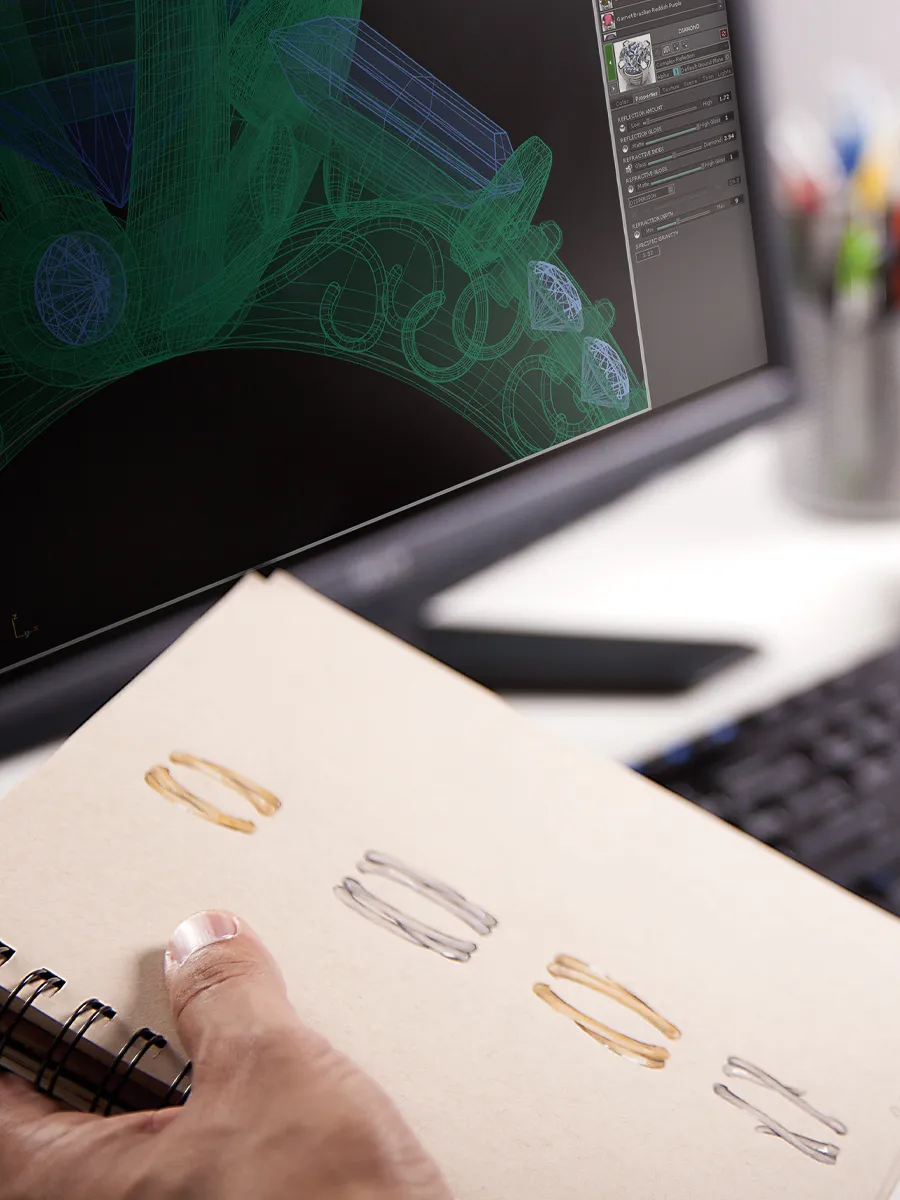 A hand holding a sketchbook with ring designs, displayed alongside a computer screen showing 3D jewelry modeling.