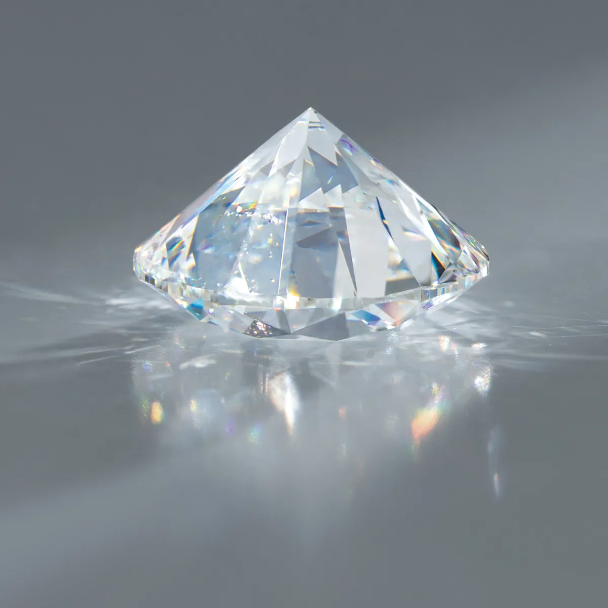 A sparkling lab-grown diamond in a pyramid shape, reflecting light on a smooth surface.