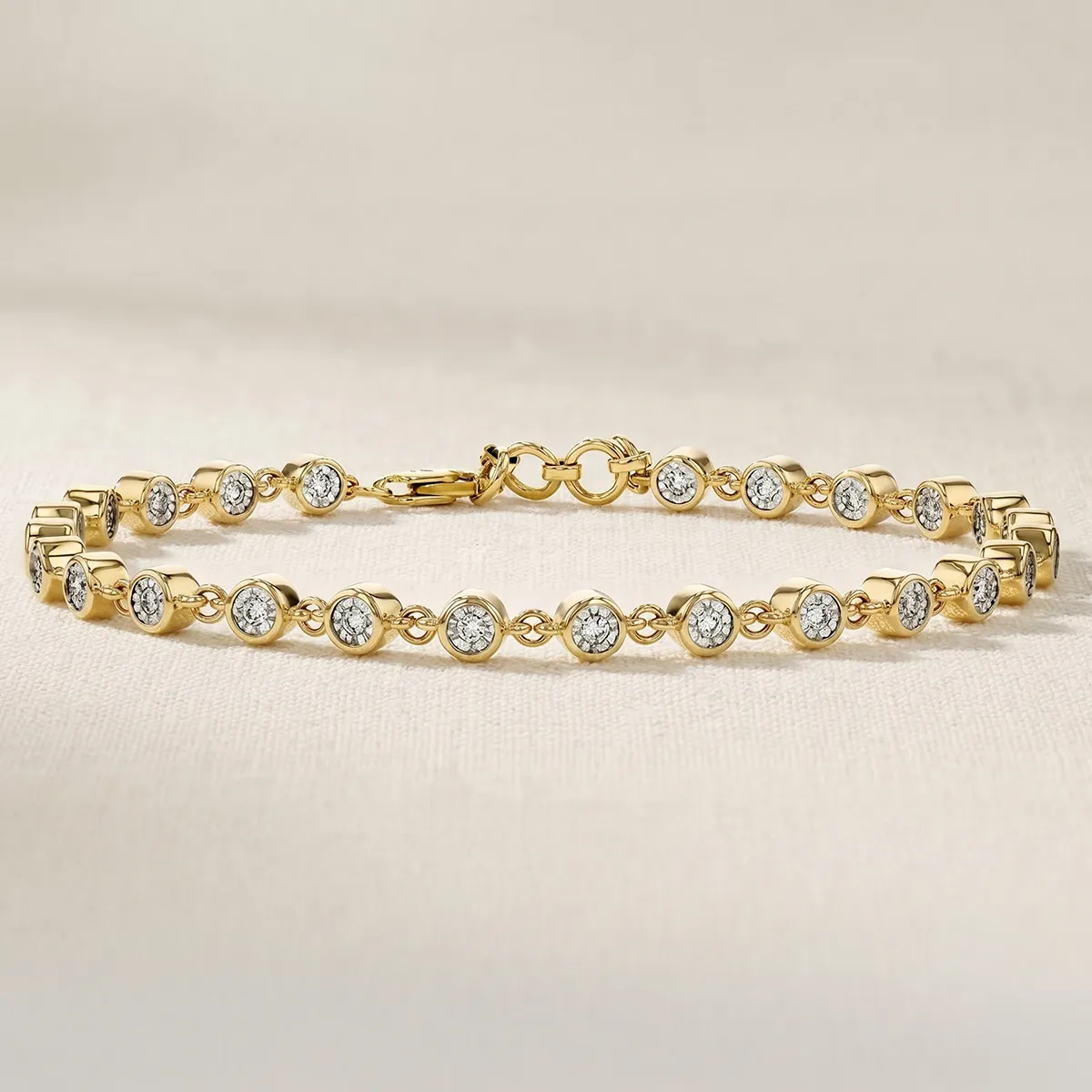 Gold bracelet with round diamond settings on a soft background.