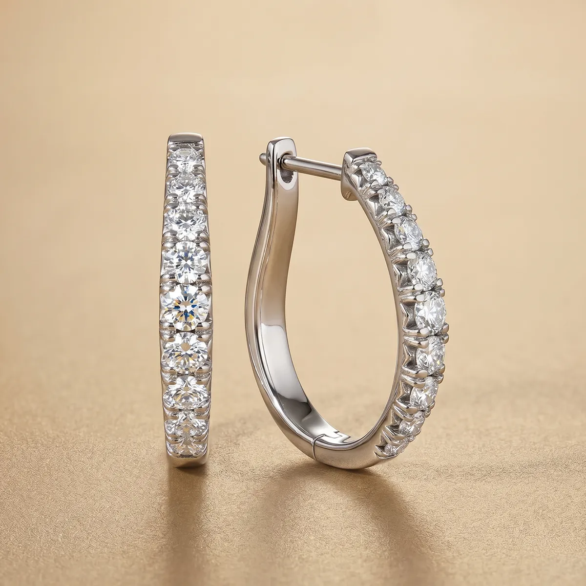 Diamond hoop earrings on a gold background at Pearce Jewelers, West Lebanon, NH.