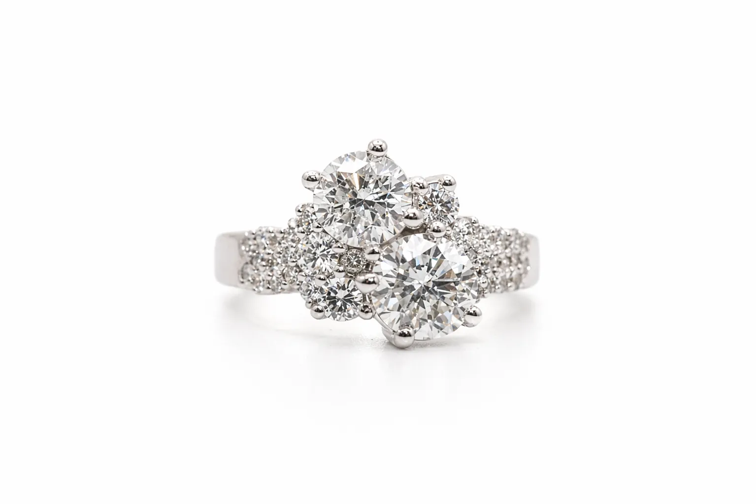 Elegant diamond ring with two large stones and smaller accents on a white background.