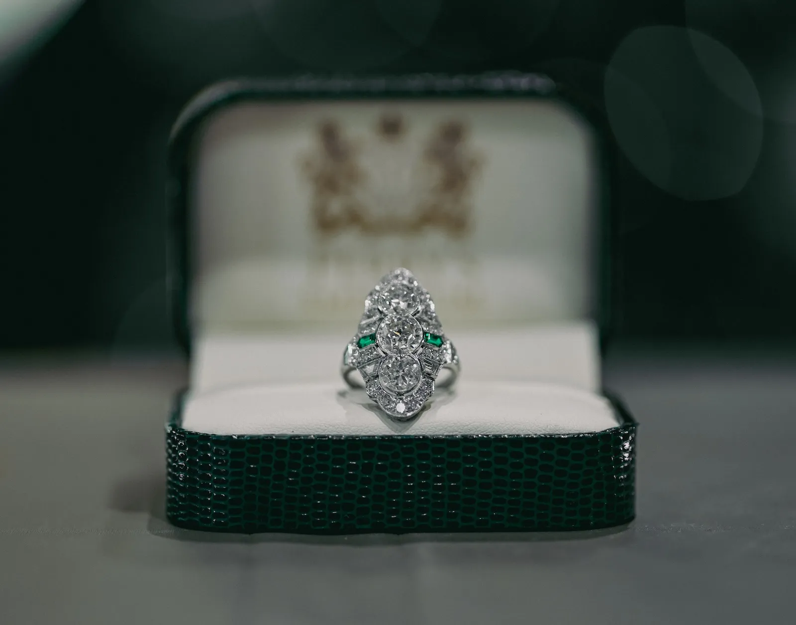 Elegant vintage ring with diamonds and emeralds in a green velvet box. Click to check out our social for more unique finds.