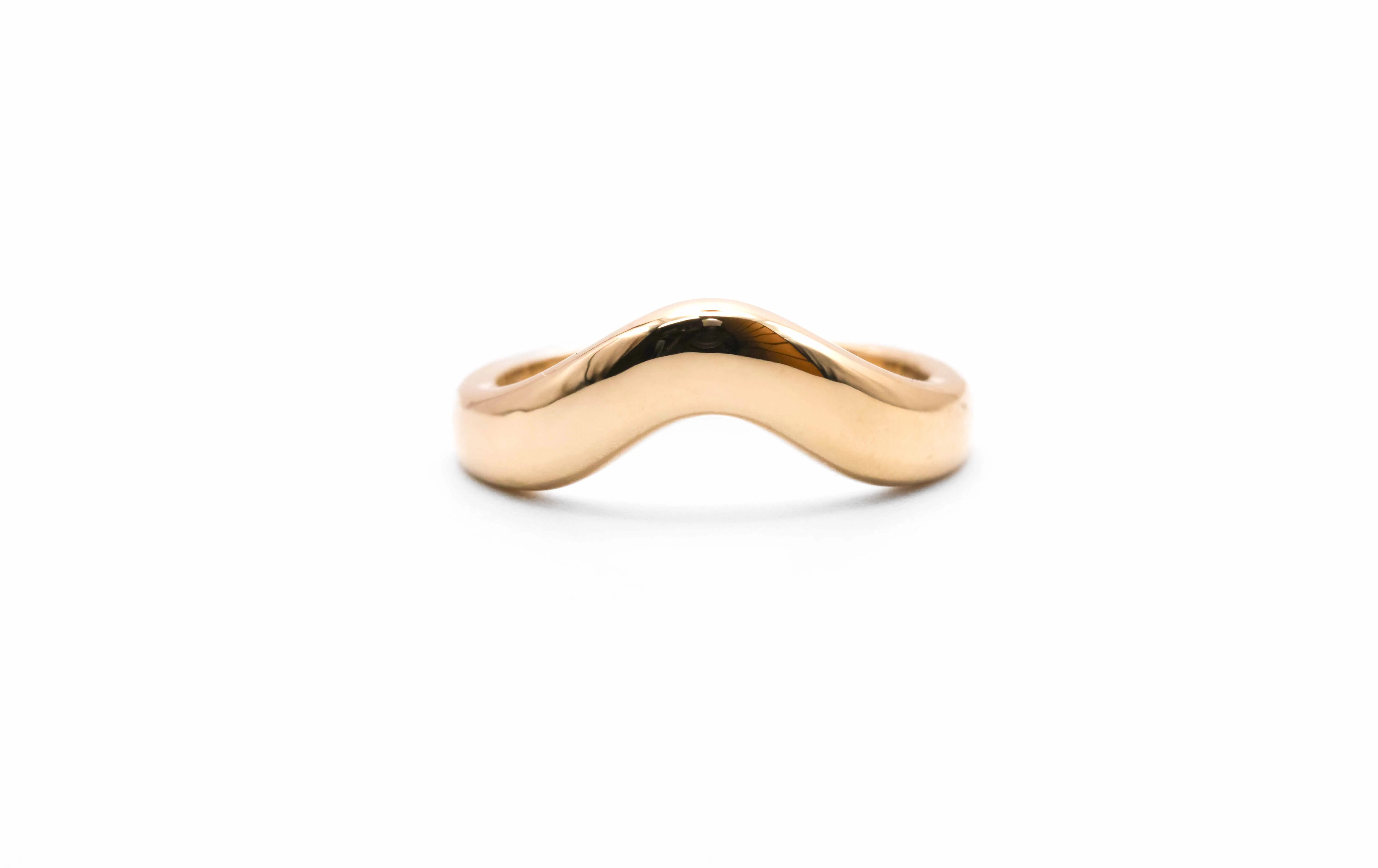 Gold wave-shaped ring displayed on a white background. Visit Perry's Emporium for fine jewelry and engagement rings.
