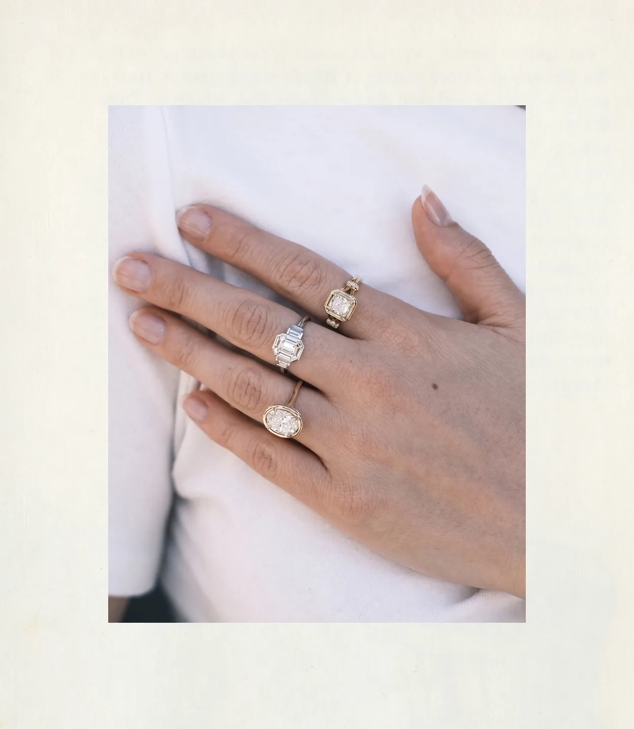 Hand with three rings featuring large gemstones, displayed on a white background.