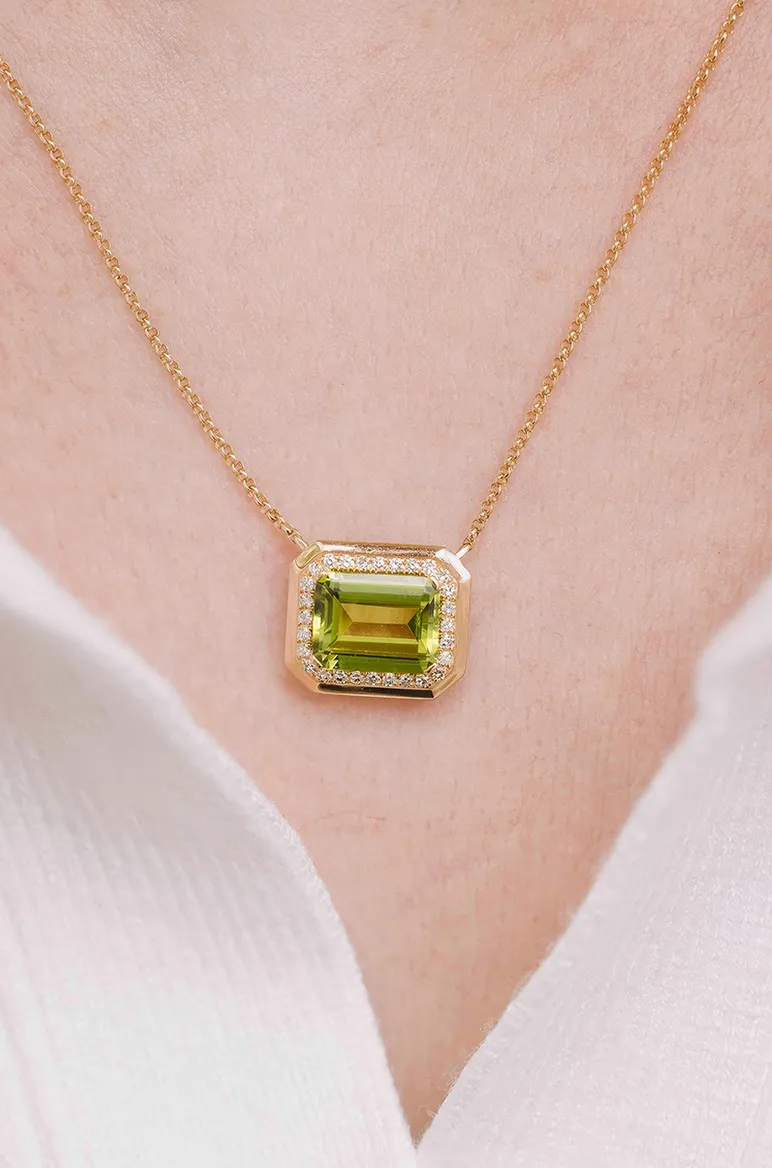 Emerald-cut peridot pendant on a gold chain.
